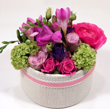 Spring flower box with purple freesias and roses