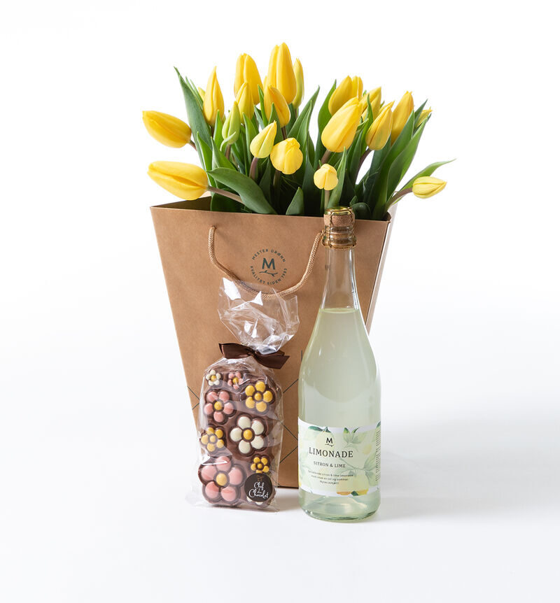 Yellow tulip bouquet in gift bag with chocolate